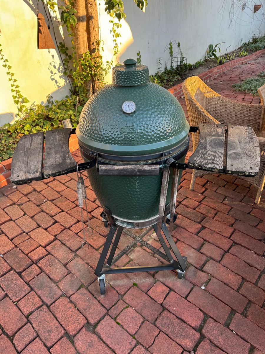 Big Green Egg ceramic grill on a brick patio