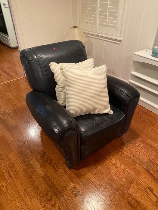 Black leather club chair with white pillows