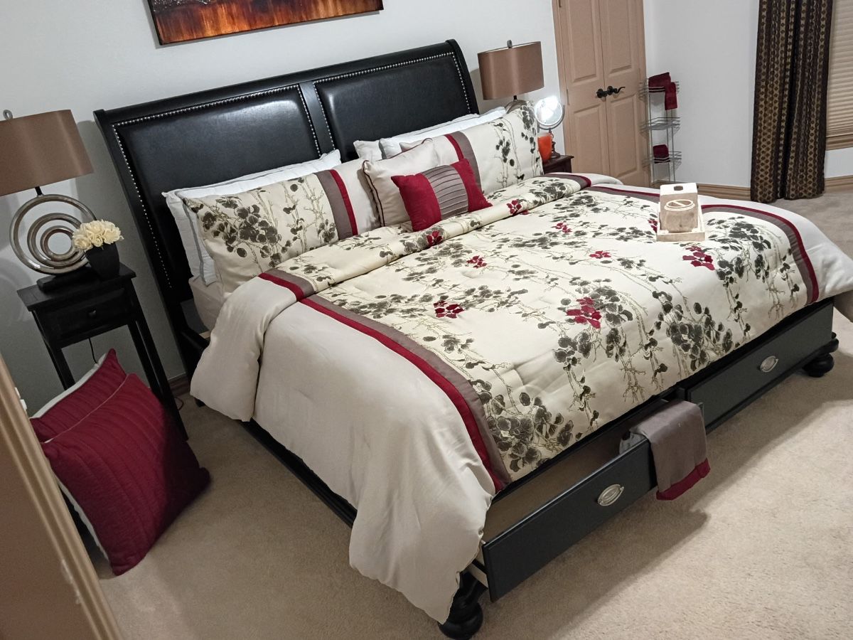 Black sleigh bed with floral bedding and matching nightstand