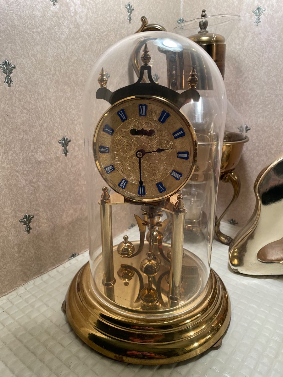 Brass anniversary clock under a glass dome
