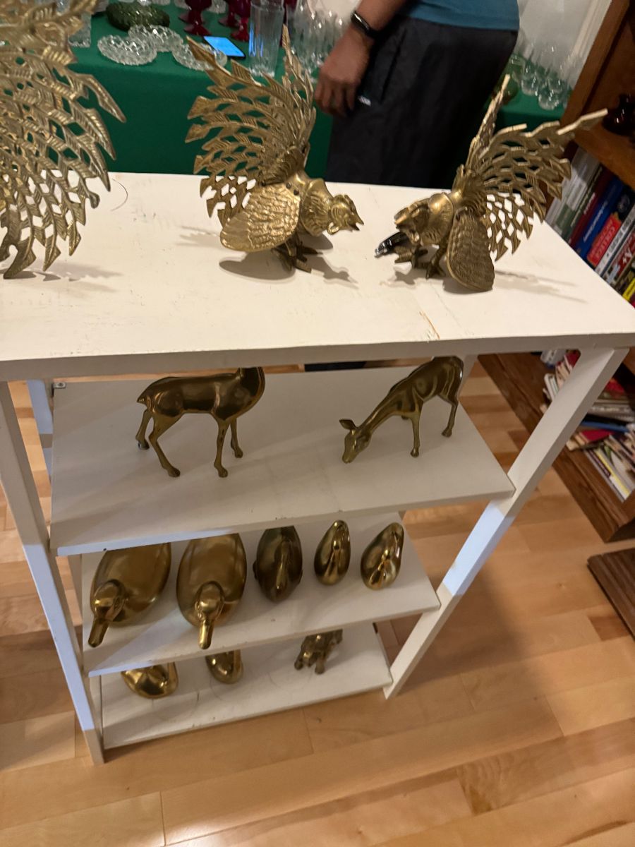 Brass peacocks, deer and birds on white shelves