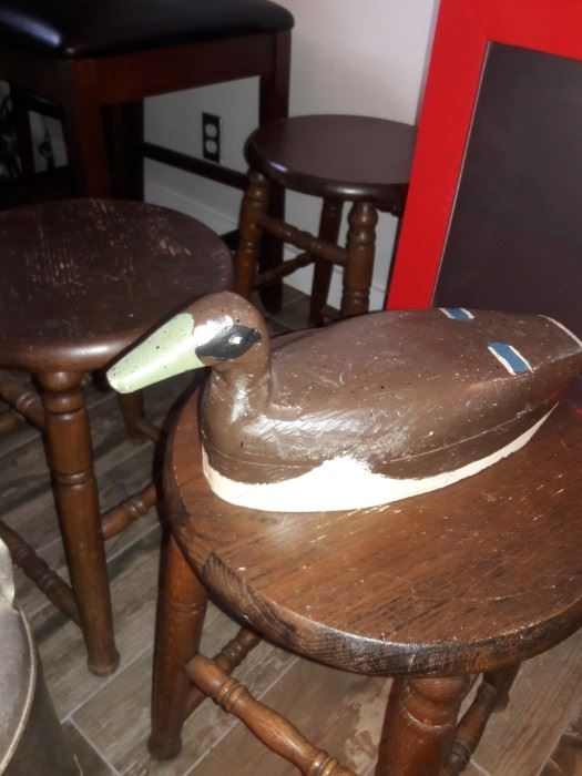 Carved duck decoy on a wooden stool