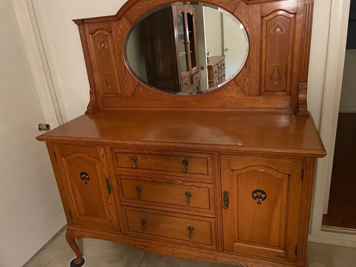 Carved oak sideboard with oval beveled mirror