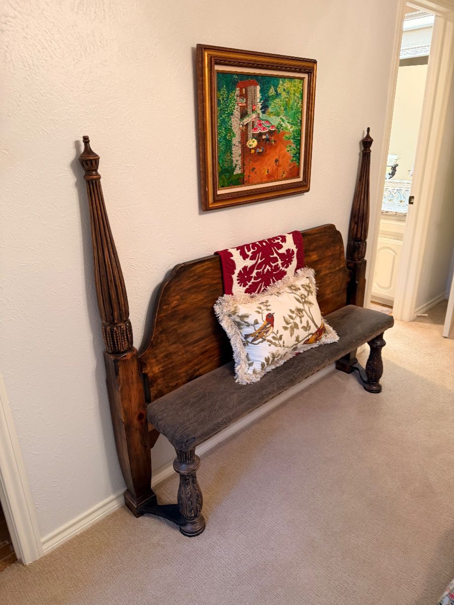 Carved wooden bench with a framed landscape