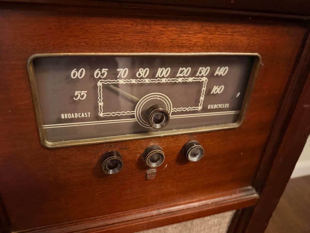 Close-up of a vintage console radio broadcast dial and knobs
