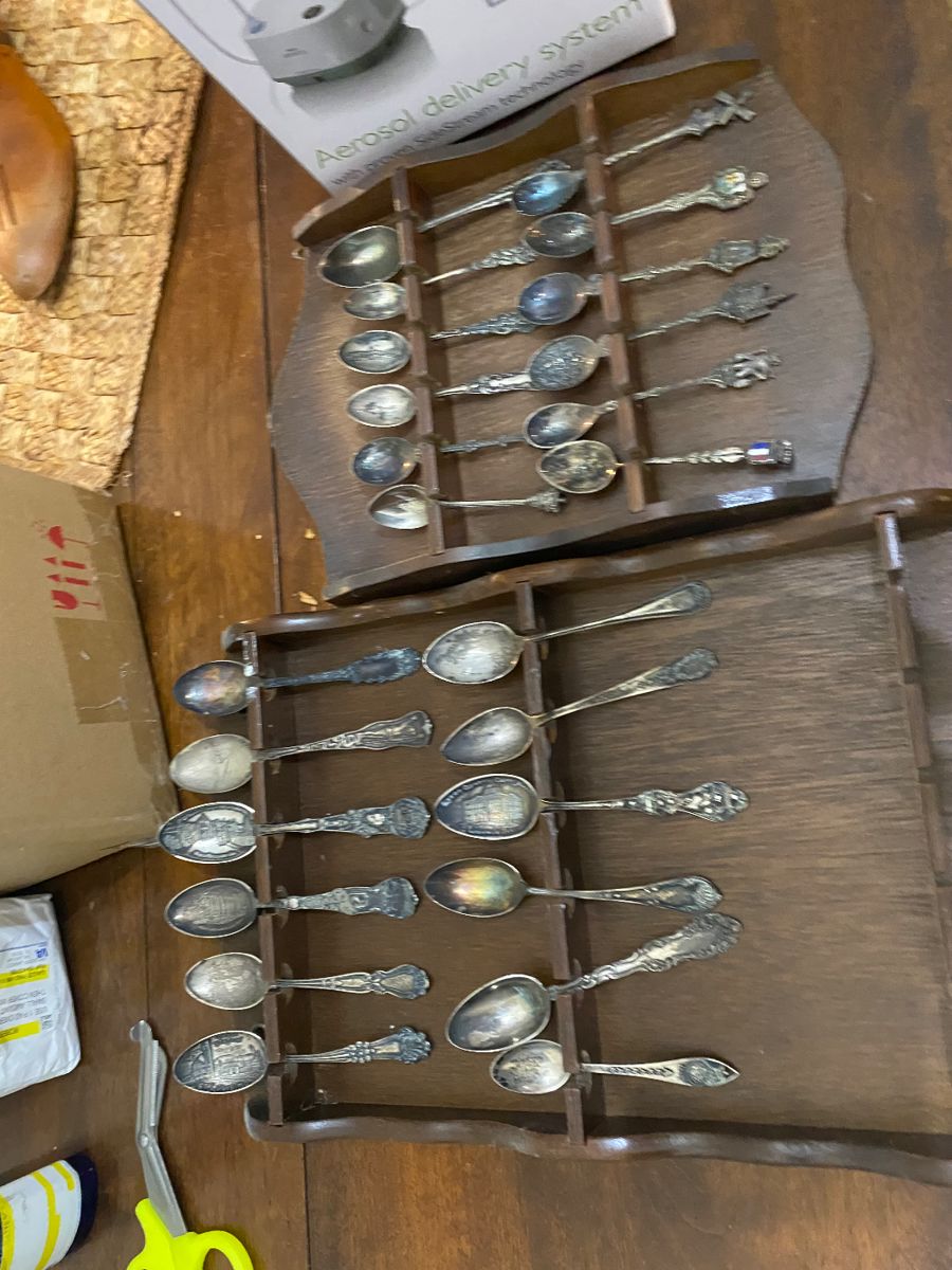 Collection of souvenir spoons in wooden racks