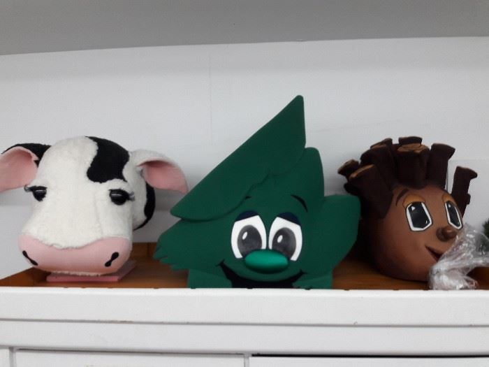 Cow, leaf and hedgehog foam costume heads on a shelf