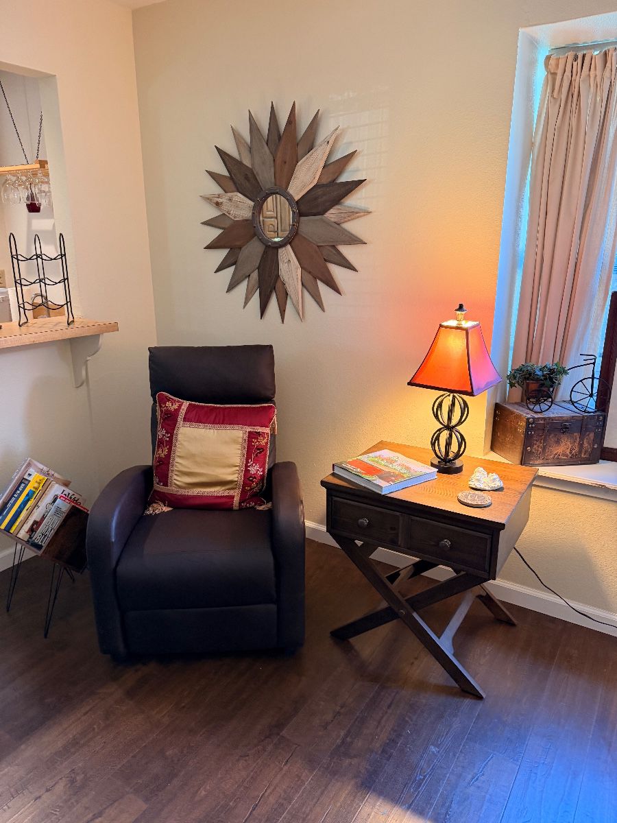 Dark leather recliner, X-base side table and sunburst wall mirror