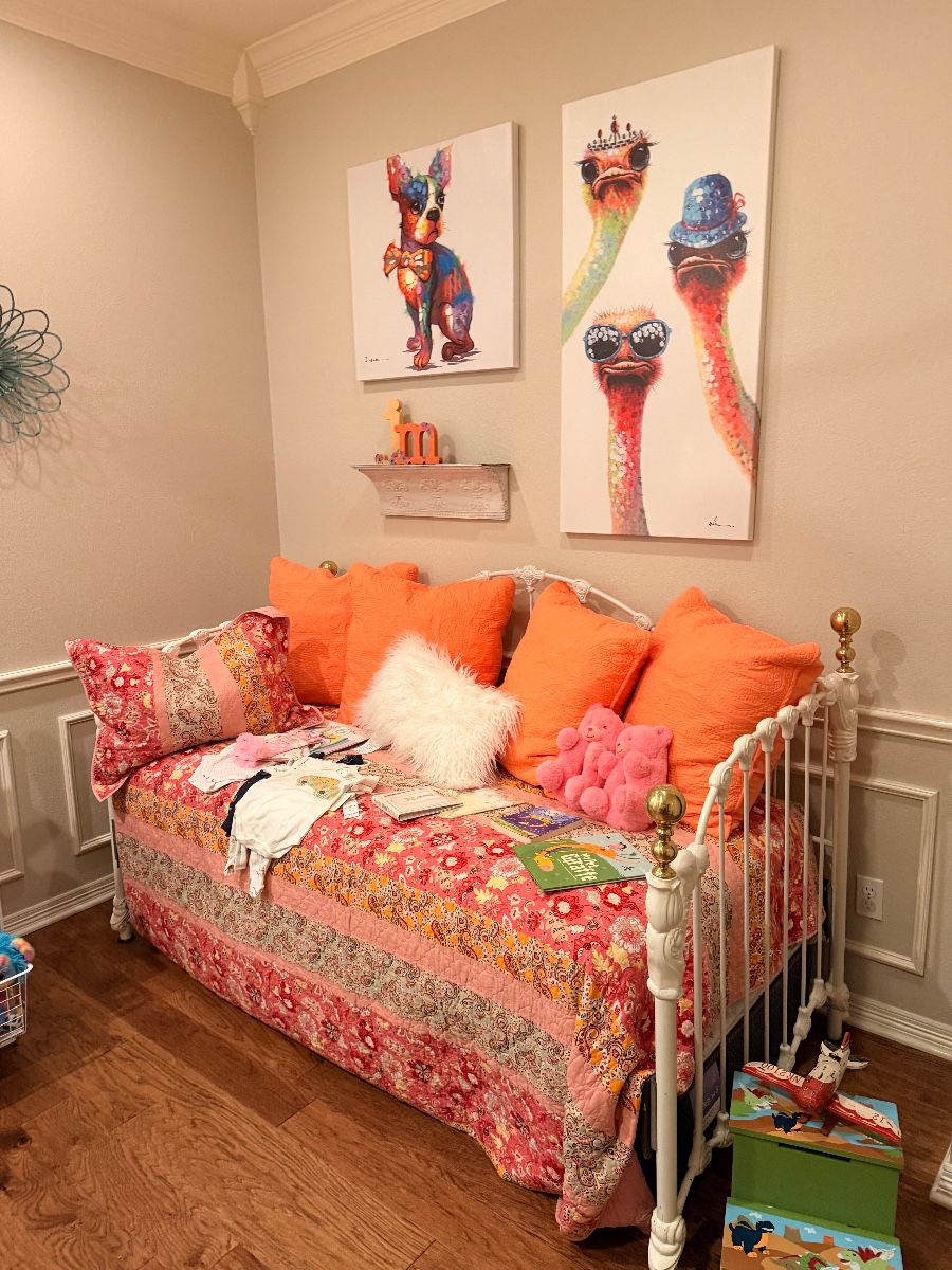 Daybed with orange pillows and colorful animal art prints