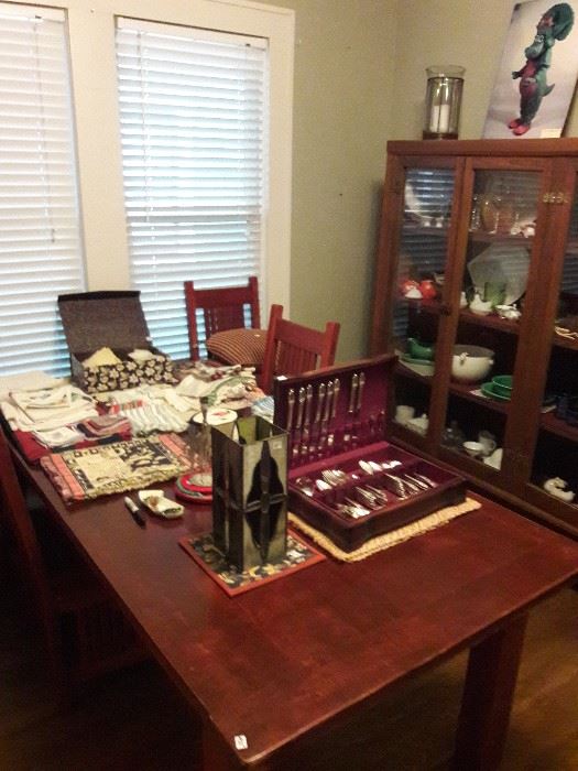 Dining table set with vintage silverware and a china cabinet
