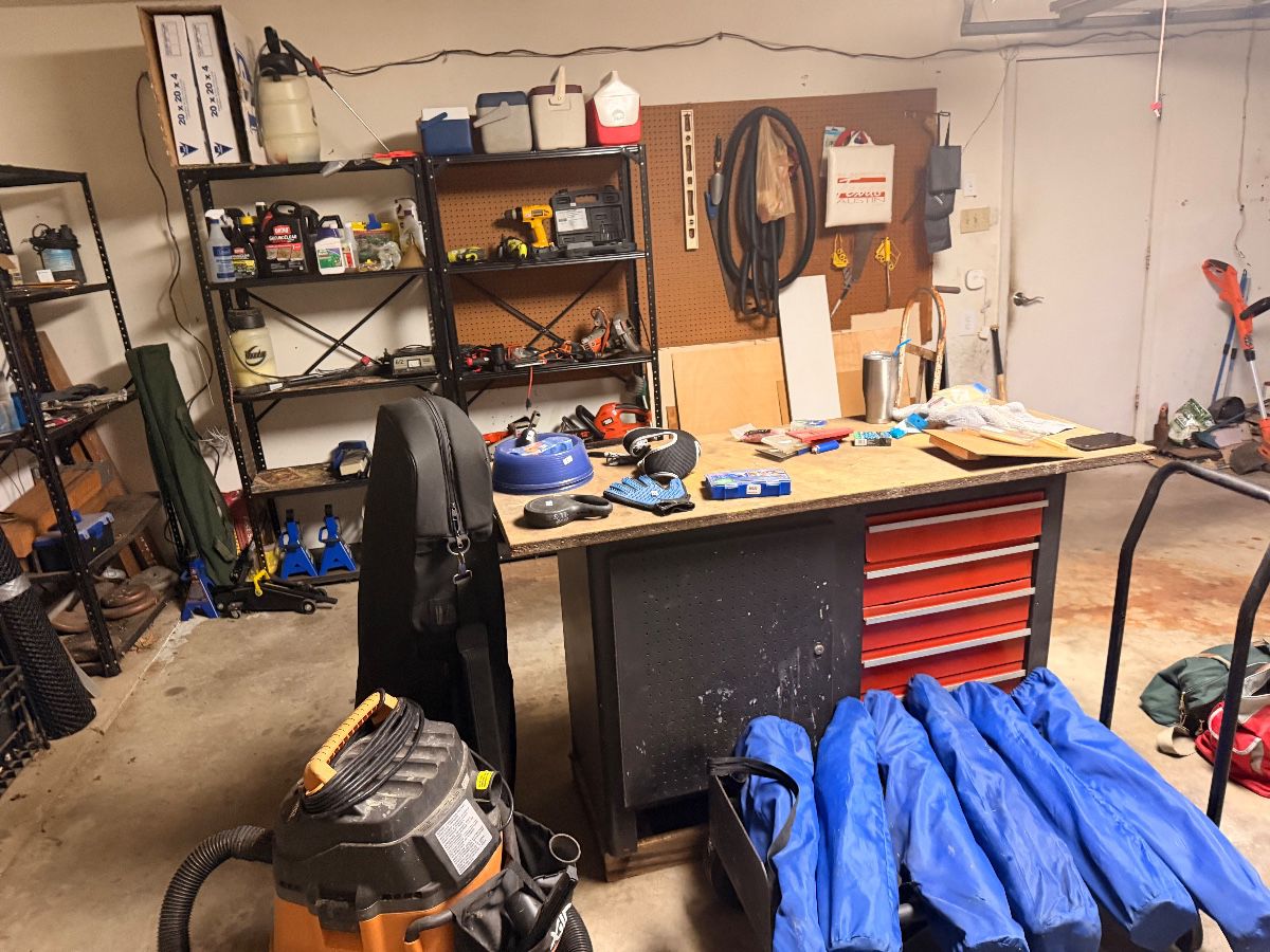 Garage workbench with red rolling tool chest and shop vac