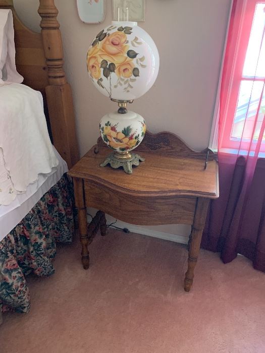 Hand-painted rose globe lamp on an oak nightstand