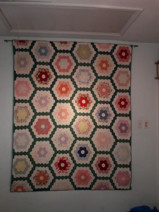 Hexagon flower garden quilt hanging on the wall