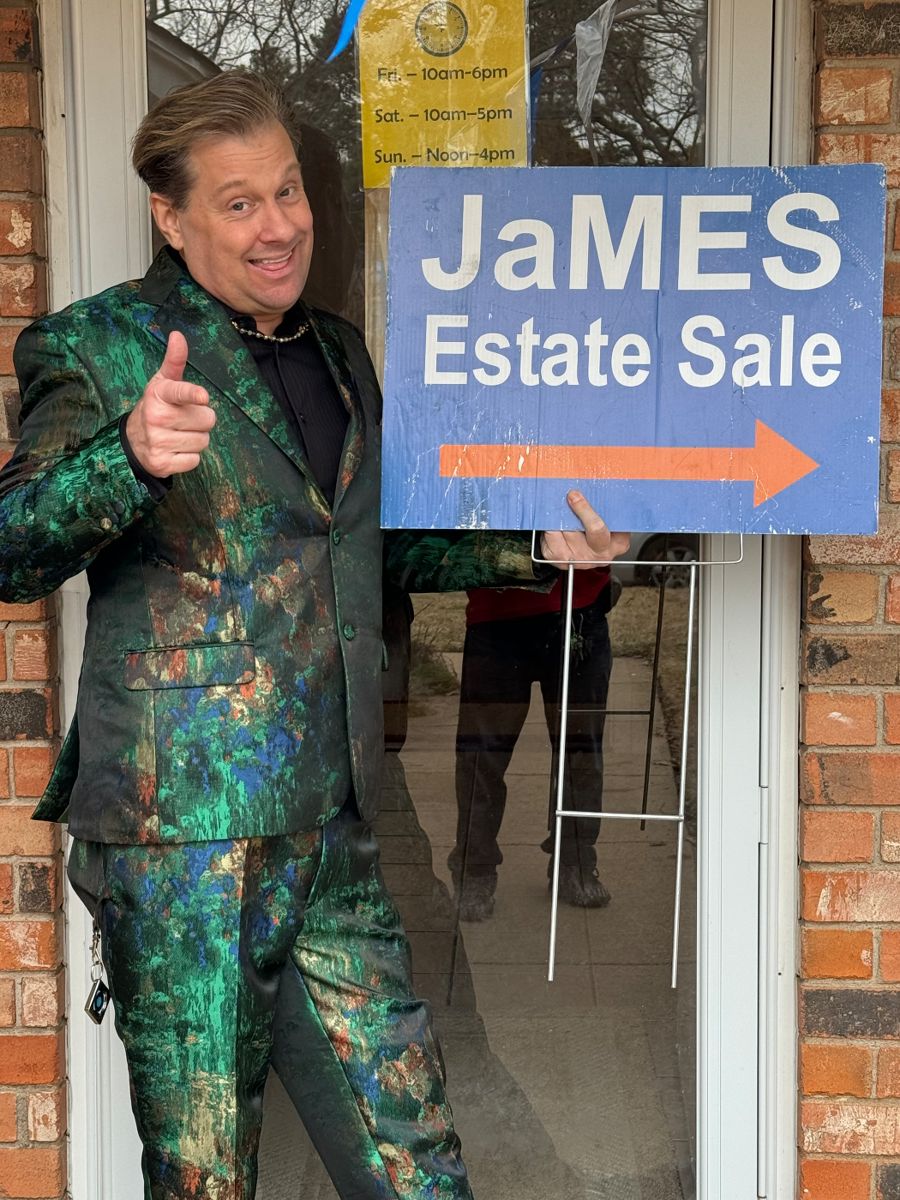 James Major of James Major Estate Sales in a green patterned suit with his sale sign
