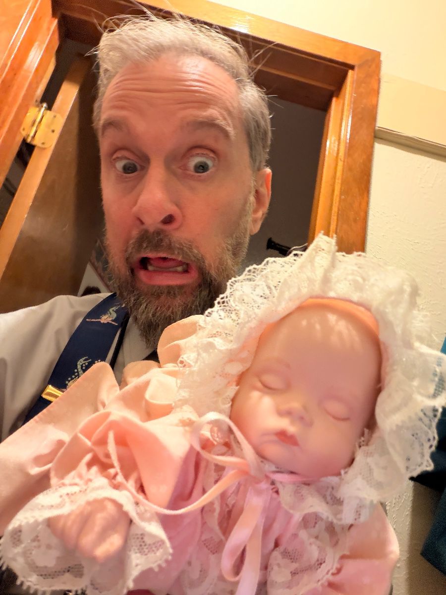 James Major of James Major Estate Sales with a baby doll at the Arlington sale