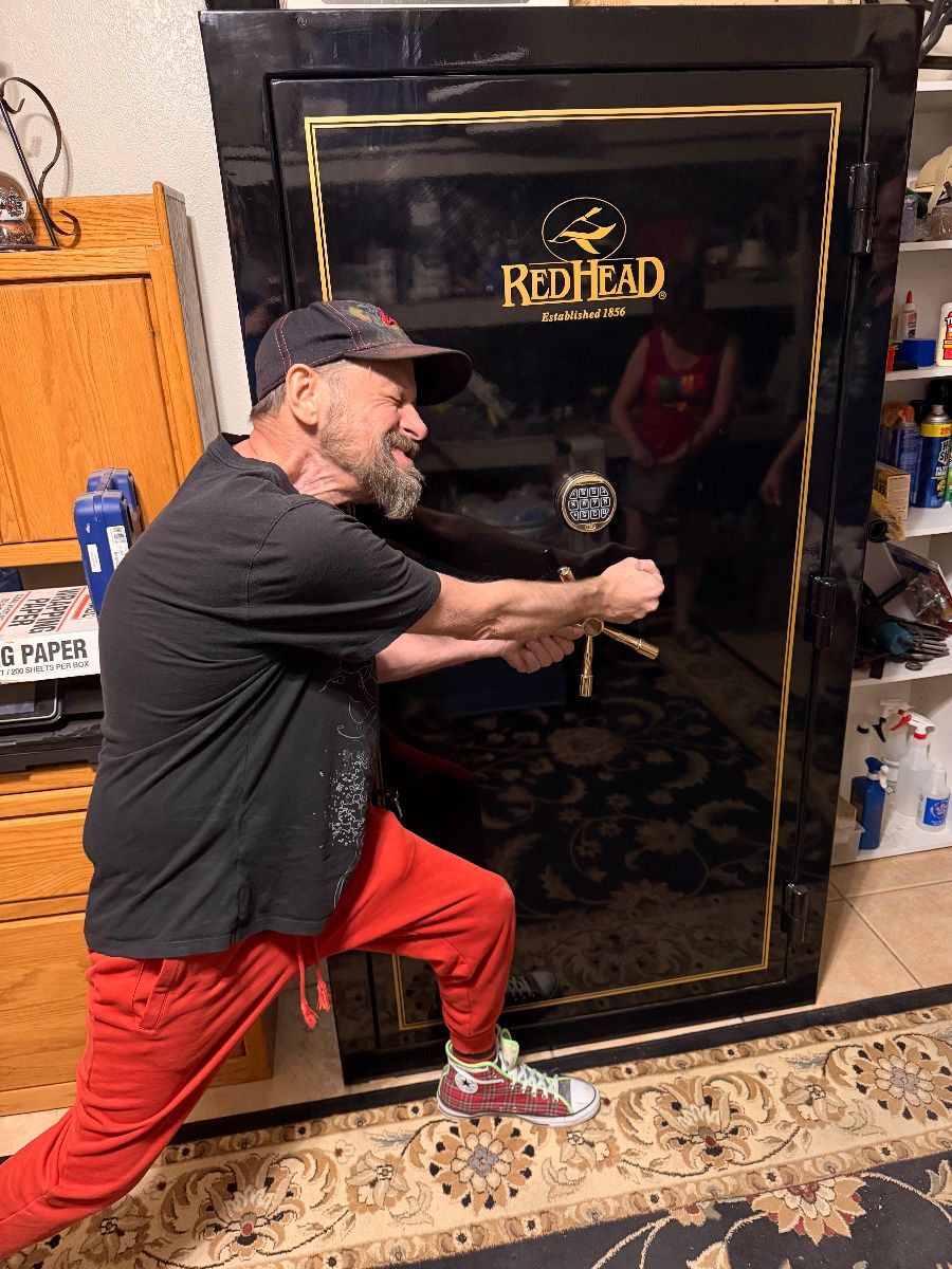 James Major posing beside a RedHead gun safe at the Fort Worth estate sale