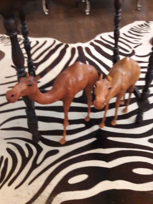 Leather camel figures on a zebra rug