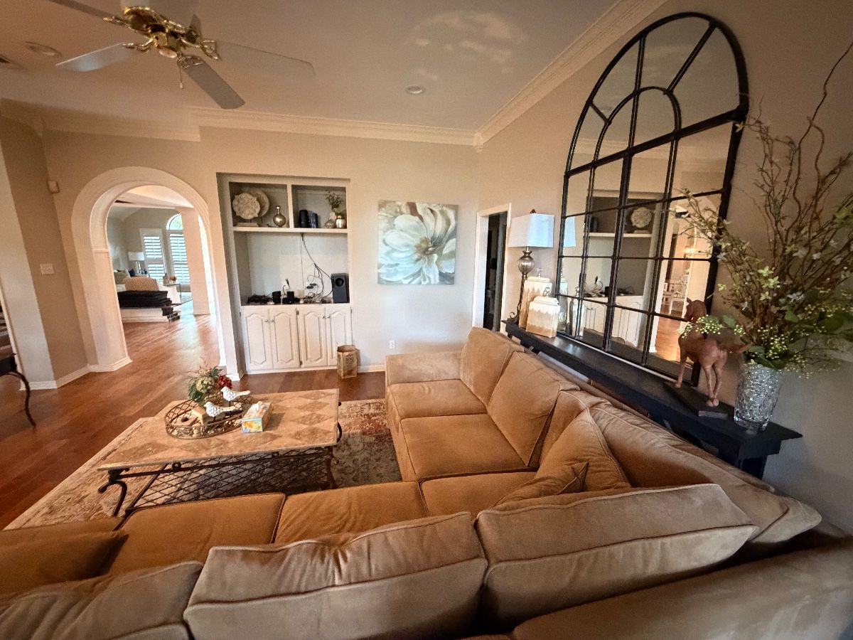 Living room with a large sectional sofa and arched window mirror