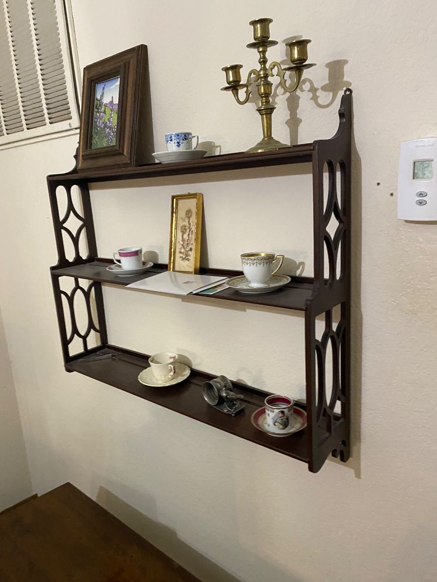 Mahogany wall shelf with teacups and brass candelabra