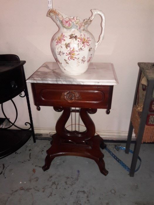 Marble top lyre base stand with a floral pitcher