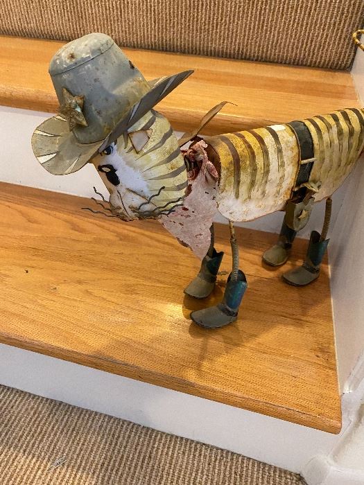 Metal cow sculpture in a cowboy hat and boots