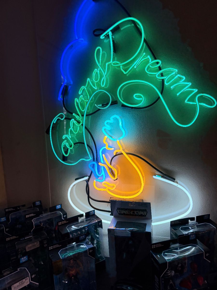Neon wall sign above a game room setup