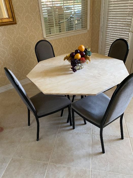 Octagonal marble dining table with black chairs