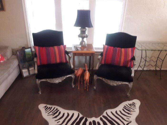 Pair of black velvet armchairs on a zebra hide rug