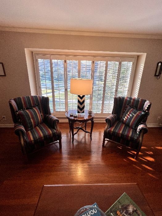Pair of striped wingback chairs by plantation shutters