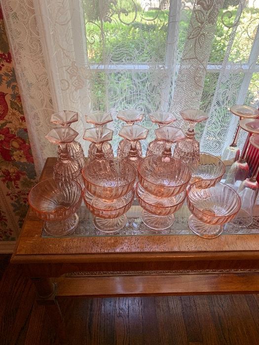 Pink Depression glass stemware on a sideboard