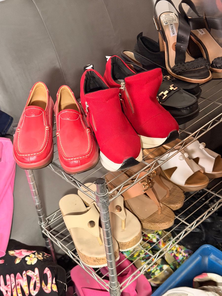 Rack of women's shoes including red loafers and wedge sandals