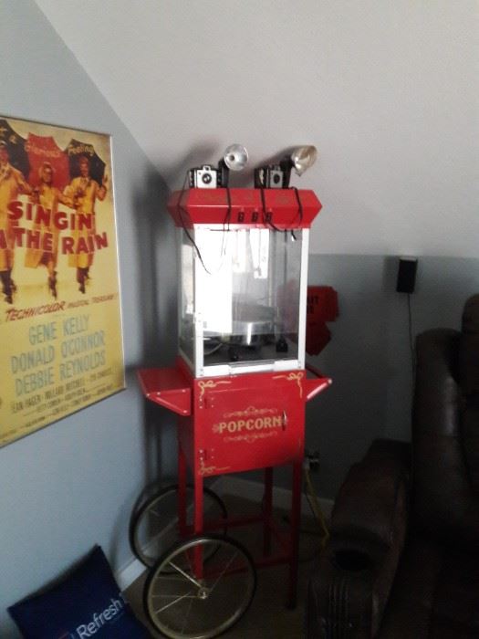 Red popcorn cart with a Singin' in the Rain poster