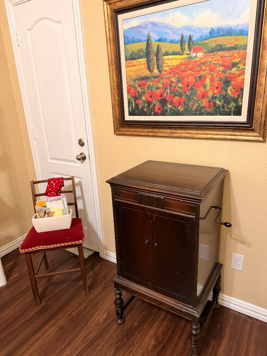 Red poppy field oil painting above a wood cabinet