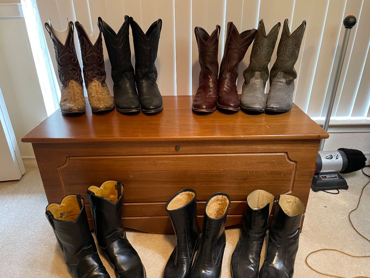 Row of leather cowboy boots on a wooden chest
