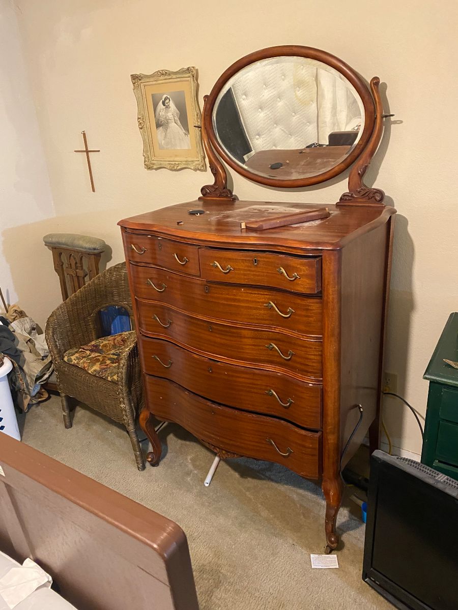 Serpentine dresser with swiveling oval mirror