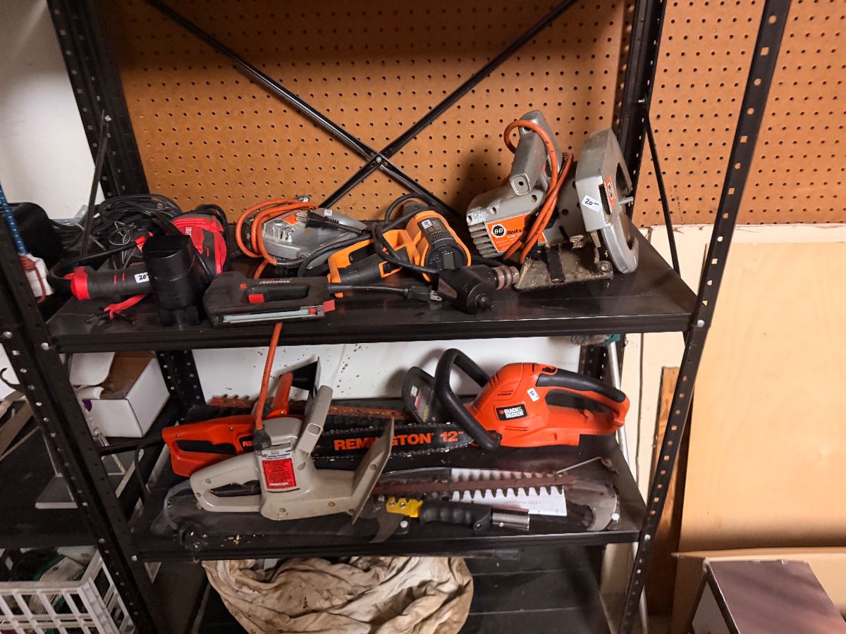 Shelf of power tools including saws and a Remington chainsaw