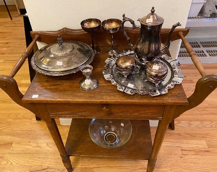 Silver plate tea service on a wooden tea cart