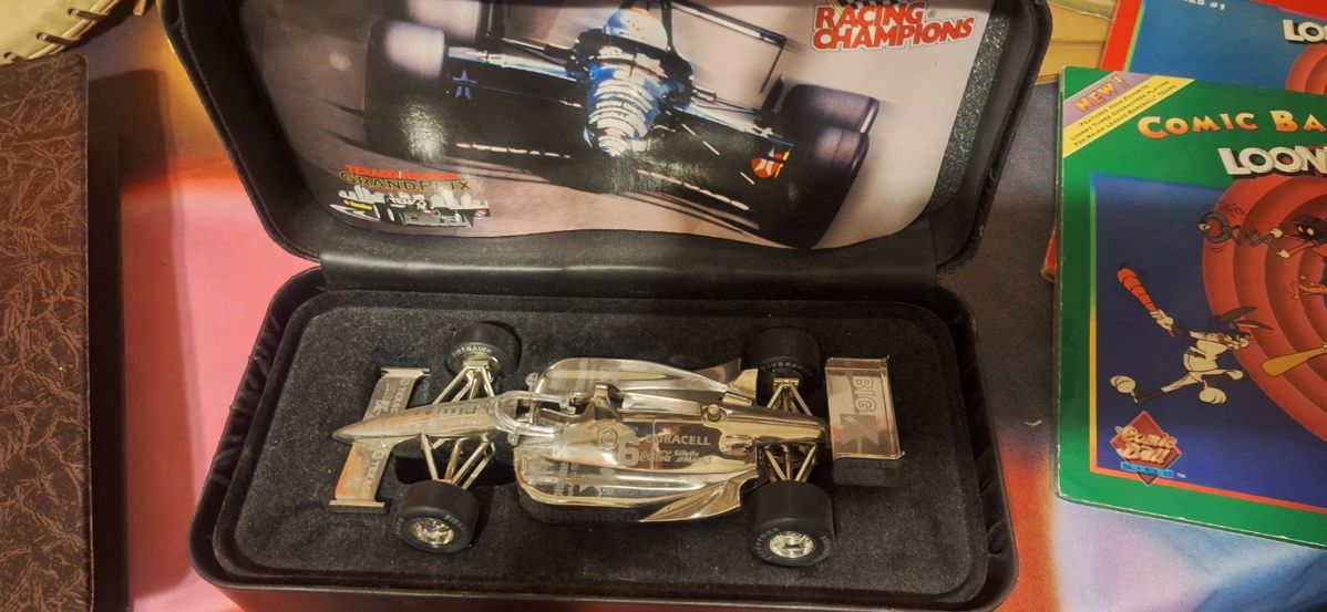 Silver race car replica in a display case