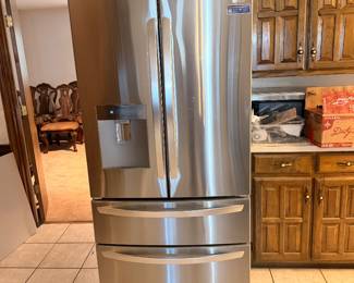 Stainless steel French door refrigerator in an oak kitchen at the Fort Worth estate sale