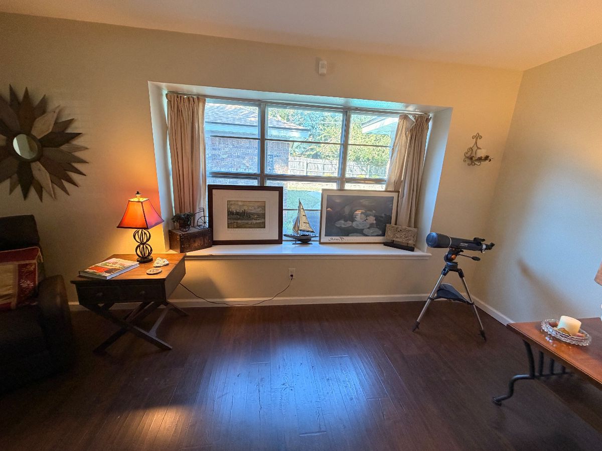 Sunny living room with bay window, lamp tables and telescope at a Hurst estate sale