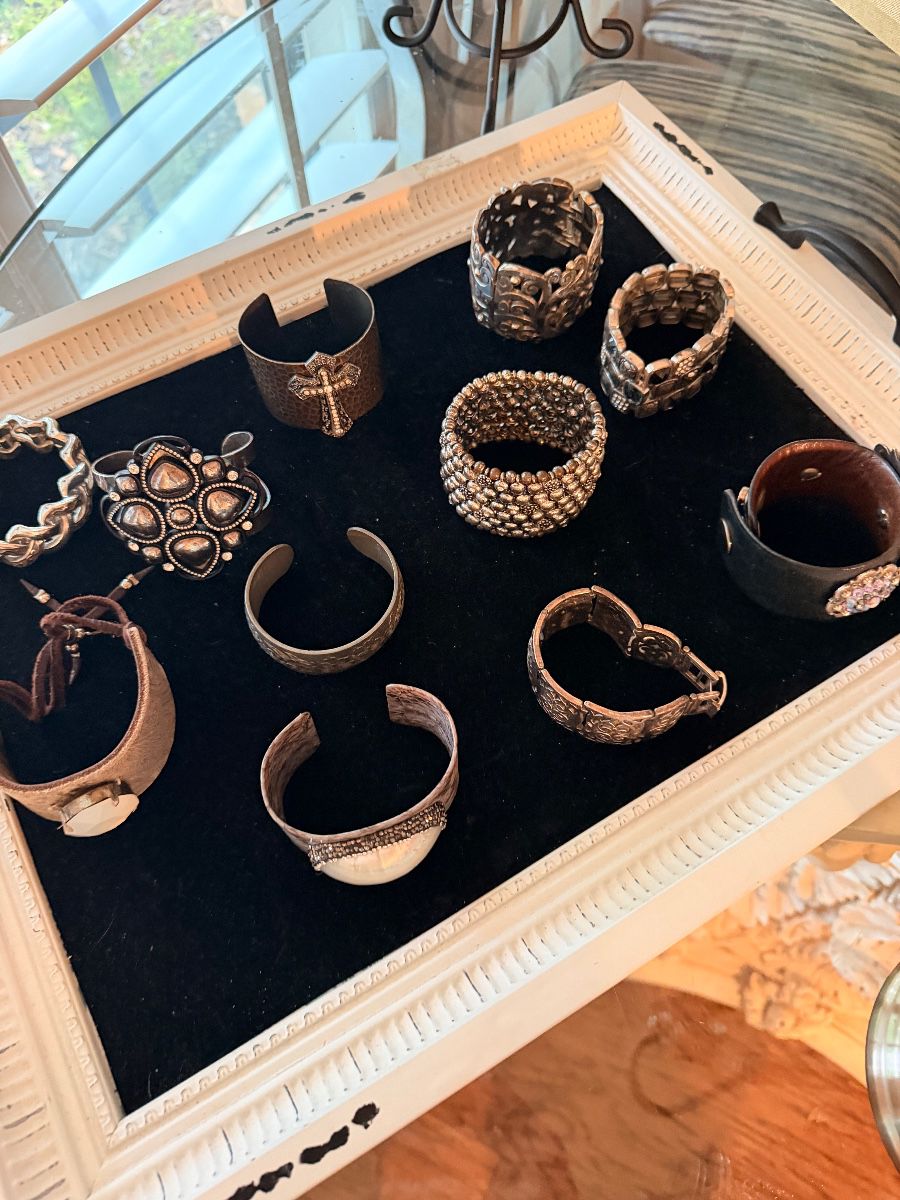 Tray of silver tone cuff bracelets