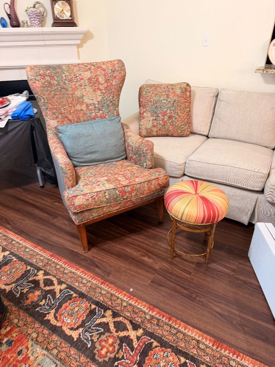 Upholstered wingback chair beside a settee
