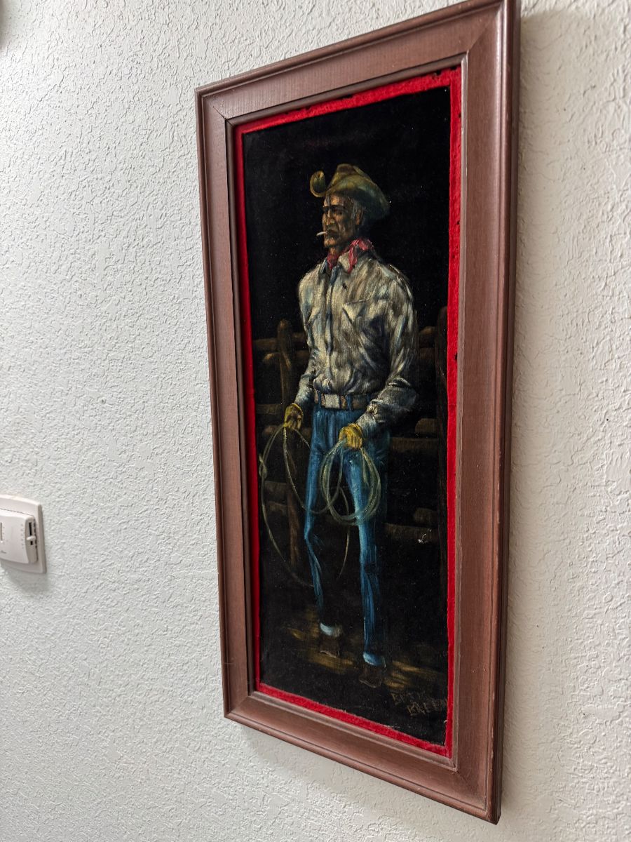 Velvet cowboy painting in a red frame